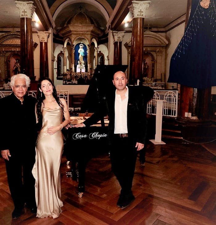Juan Estay with fellow performers in front of Casa Chopin piano inside a historic church